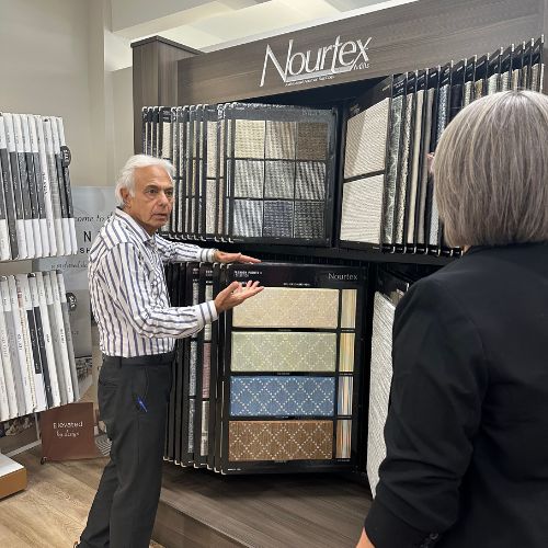 Man in store with customer, with nourtex sign above